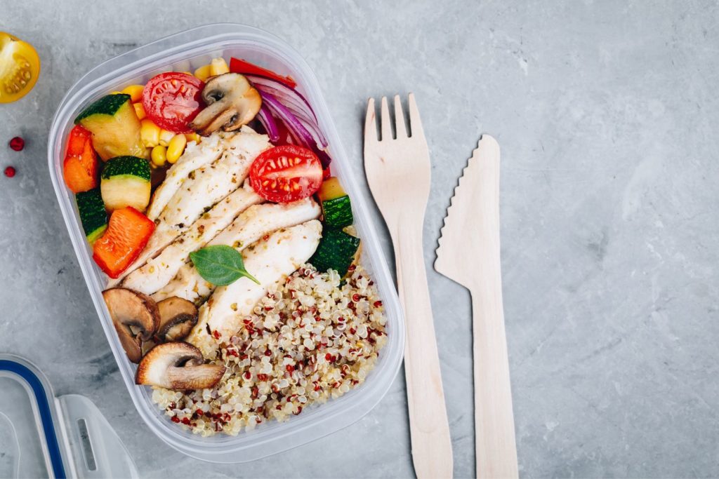 a meal prep container filled with healthy foods on a kitchen counter